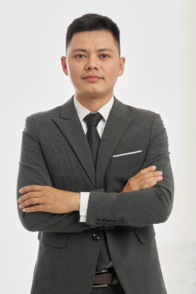 Portrait of a confident businessman in a formal suit with arms crossed, isolated on white background.